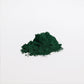 Close-up of a green mound of ViableSupps Organic Spirulina Powder on a white background.