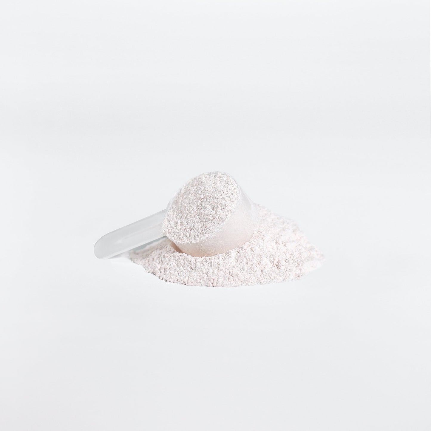 A detailed view of ViableSupps BCAA Shock Powder’s fruit punch formula, featuring a scoop resting atop a pile of fine, white powder.