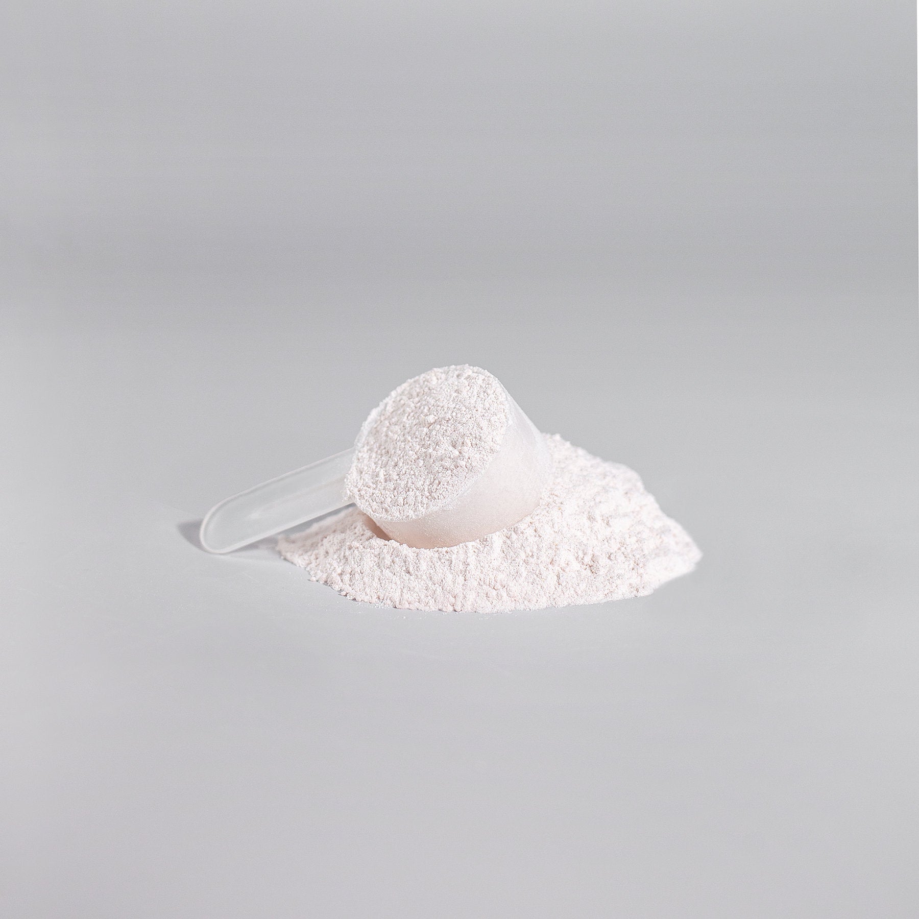 Close-up of a clear scoop filled with fine pre-workout powder from ViableSupps Nitric Shock, enhancing energy and focus